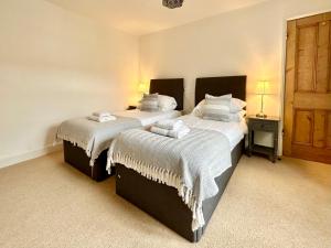 1 dormitorio con 2 camas y mantas blancas en The Annex - central Helmsley with parking, en Helmsley