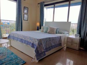 1 dormitorio con cama y ventana grande en 6 - Studio Velankanni Heights, Behaind Nanavati Hospital, Vile Parle by Connekt Homes, en Bombay