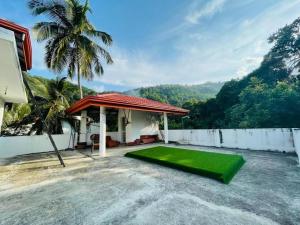 a house with a yard with a green lawn at Hermitage Villa in Kandy