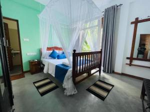 a bedroom with a bed with a canopy and a window at Hermitage Villa in Kandy