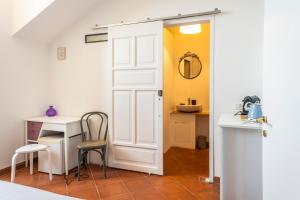 a door leading into a kitchen with a table and chair at Palazzo Oddo in Albenga