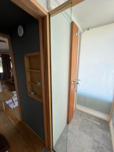 - une porte de douche en verre dans une chambre dans l'établissement Corto, à Leucade