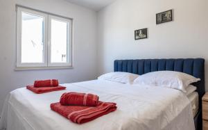a bedroom with a large bed with red towels on it at Apartman Tonči Bruno - obnovljen 2026 sa novim dvorištem in Pag