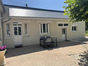 a house with a table and chairs in front of it at Les ROSEAUX A la Campagne au centre des chateaux de la Loire in Feings