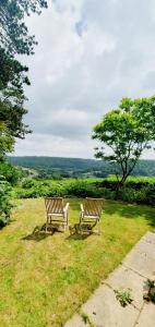 two wooden benches sitting in a field of grass at Garden flat in Bath