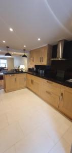 uma grande cozinha com armários de madeira e bancadas pretas em Garden flat em Bath