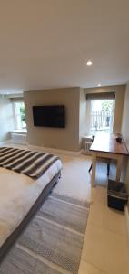 a bedroom with a bed and a flat screen tv at Garden flat in Bath
