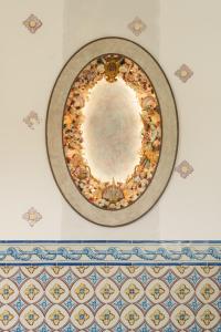 a plate on a wall with a mirror on it at Vermelho Melides in Melides