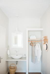 a white bathroom with a sink and a mirror at Odyssey Suites in Poros +117 photos