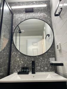a bathroom with a mirror and a sink at Haneemanim Apartments in Haifa