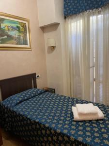 ein Schlafzimmer mit einem blauen Bett mit zwei Handtüchern darauf in der Unterkunft Bye Rome Guesthouse in Rom