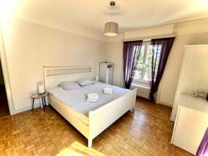 een slaapkamer met een groot wit bed in een kamer bij CH Apartment Lausanne Gare in Lausanne