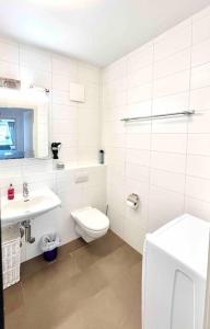 een witte badkamer met een toilet en een wastafel bij CH Apartment Lausanne Gare in Lausanne