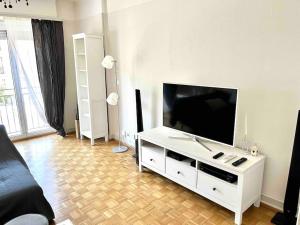 een woonkamer met een flatscreen-tv op een witte kast bij CH Apartment Lausanne Gare in Lausanne