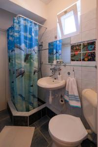 a bathroom with a sink and a toilet and a shower at 4 Évszak Apartman in Gyula