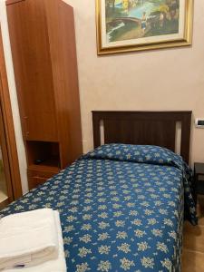 a bedroom with a bed with a blue comforter at Bye Rome Guesthouse in Rome