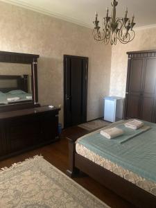a bedroom with two beds and a dresser and a mirror at REAL Tashkent in Tashkent