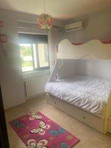 1 dormitorio con cama blanca y alfombra roja en 2 Bedroom Apartment, en Shkodër