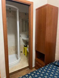 a bathroom with a shower and a bed and a sink at Bye Rome Guesthouse in Rome