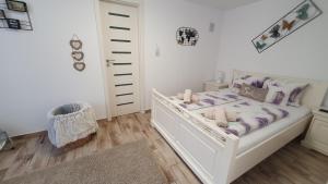 um quarto com uma cama branca com lençóis roxos e velas em Smiley Rezident em Sibiu