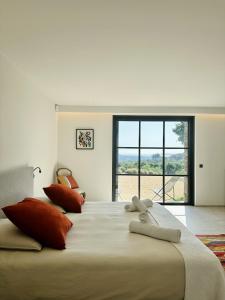 a bedroom with a large bed with a large window at Le Mas Saint Michel Grimaud in Grimaud