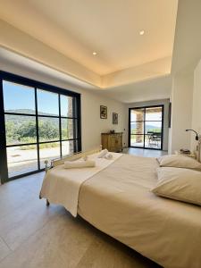 a large bedroom with a large bed with large windows at Le Mas Saint Michel Grimaud in Grimaud