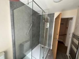 a shower with a glass door in a bathroom at The Coach House in Stamford