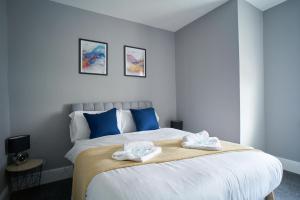 a bedroom with a large bed with towels on it at West Apartment in Coatbridge