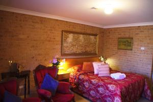 a bedroom with a bed and a brick wall at White Lanterns Motel in Armidale