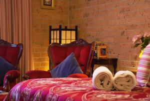 White Lanterns Motel في أرميدال: غرفة نوم مع سرير مع قبعة عليه
