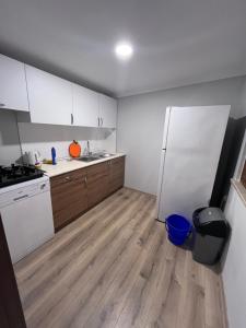 eine Küche mit einem weißen Kühlschrank und Holzböden in der Unterkunft Bayraktar apart in Pelitli