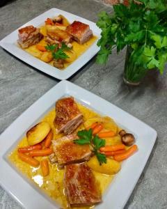 dos platos de comida con carne y verduras en una mesa en Motel Dačo, en Vitez