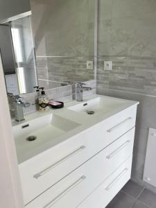 a bathroom with a white sink and a mirror at Maison moderne au cœur du Golfe du Morbihan ! in Plougoumelen