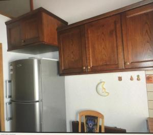 a kitchen with a refrigerator and wooden cabinets at Chalet Rosj in Moena