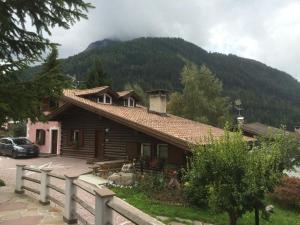 a wooden house with a mountain in the background at Chalet Rosj in Moena