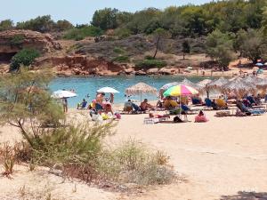 un grupo de personas en una playa con sombrillas en Solis Occasum en Aghii Apostoli