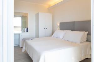 切爾維亞的住宿－Kiss Beachfront Hotel & Restaurant，卧室设有一张白色大床和一扇窗户。