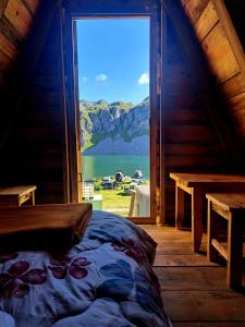 a bed in a room with a large window at Mountain cottage Captain's Lake, Kapetanovo jezero in Kolašin