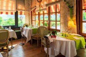 Hotel Munsch Restaurant & Wellness, Colmar Nord - Haut-Koenigsbourg في سانت هيبوليت: مطعم بطاولتين وكراسي ونوافذ