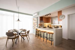 a kitchen and dining room with a table and chairs at Beautiful Boutique House Near the Beach in Costa da Caparica