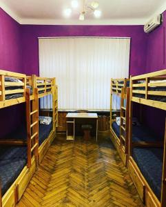 卡爾可夫的住宿－Хостел Центр，一间设有三张双层床和紫色墙壁的客房