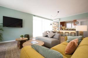a living room with a yellow couch and a table at Beautiful Boutique House Near the Beach in Costa da Caparica