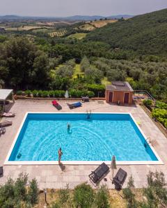 a person standing in a swimming pool in a house at Agriturismo Pereti in Roccatederighi