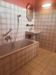 een badkamer met een bad en een wastafel bij Entre vignes et horizon Appartement avec jacuzzi privatif et piscine commune chauffée in Sablet