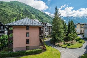 an apartment building with mountains in the background at Eden Studio Chamonix Centre in Chamonix