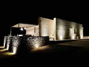 un bâtiment la nuit avec des lumières allumées dans l'établissement Bimmisca Country House, à Noto