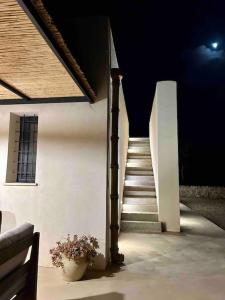 una escalera con una maceta de flores y una escalera en Bimmisca Country House en Noto