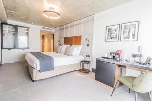 a hotel room with a bed and a desk and a desk at The Londoner Hotel Sliema in Sliema