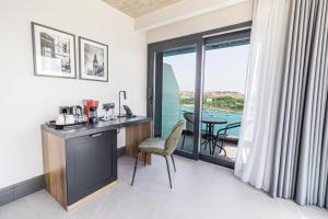 a hotel room with a desk and a view of the ocean at The Londoner Hotel Sliema in Sliema