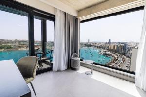 a living room with a view of the ocean at The Londoner Hotel Sliema in Sliema